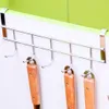 A metal over-the-door hook rack with several kitchen utensils hanging from it. Produktbild-Vorschau