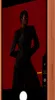 A person is posing in front of a red backdrop, captured through a smartphone camera interface. Náhľad obrázku produktu