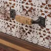 A close-up view of a drawer pull on a piece of furniture with decorative detailing. Voir les images du produit