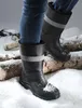 A person wearing black winter boots standing in the snow with logs. Voir les images du produit