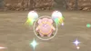 A pink Pokemon character is shown in the center of the image, surrounded by a yellow circle. Two Poké Balls are in the background, with colorful trails emanating from them. The scene appears to be a sandy or rocky environment. Produktbild-Vorschau