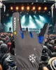 A gloved hand making a rock-and-roll gesture in front of a concert crowd and stage. Produktbild-Vorschau
