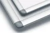 Close-up view of the corners of two silver poster frames with gray corner protectors. Voir les images du produit