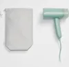 A mint green travel steamer and its storage bag are displayed against a white background. Produktbild-Vorschau