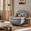 A modern living room scene featuring a gray swivel armchair, a floor lamp, and side tables. Produktbild-Vorschau