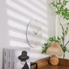 A modern living room corner with a wall clock, books, and a lamp. Voir les images du produit