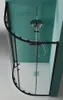 A top-down view of a modern shower enclosure with a black frame and glass doors, featuring a shower head and controls against a teal wall. Produktbild-Vorschau