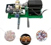 A pearl drilling machine with a tray of pearls, and two circular insets showing pearls and walnuts. Podgląd zdjęcia produktu