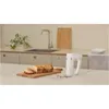 A hand mixer is shown on a kitchen counter next to a loaf of bread on a cutting board. Produktbild-Vorschau
