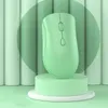 A light green wireless mouse is displayed on a green pedestal against a background of vertical light green and white cylindrical shapes. Náhled obrázku produktu