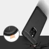 A black phone case with a carbon fiber texture is shown at an angle, with a close-up inset highlighting its protective features. Produktbild-Vorschau