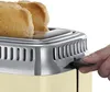 A close-up of a vintage-style cream toaster with two slices of toast emerging from the top. A hand is shown pressing down on the lever. Produktbild-Vorschau