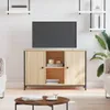 A TV stand with a TV on top, in a living room setting with a coffee table and plant. Náhled obrázku produktu