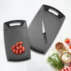 Two gray cutting boards are shown, one with tomatoes and the other with a knife. Other kitchen ingredients are also visible. Anteprima dell’immagine prodotto