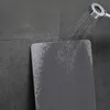 A diatomite bath mat is being sprayed with water from a shower head. Podgląd zdjęcia produktu