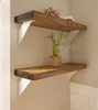 Two wooden shelves mounted on a light-colored wall, with a small potted plant on the lower shelf. Produktbild-Vorschau