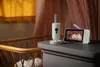 A baby monitor set is placed on a dresser next to a crib. Anteprima dell’immagine prodotto