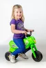 A young girl is sitting on a green toy motorcycle. Voir les images du produit