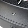 A close-up view of a small, circular, clear object with a reflective surface, possibly a light or sensor, embedded in a textured dark gray surface. A portion of a black grid pattern and a white line are visible in the upper background. Produktbild-Vorschau