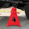 A red car jack stand is supporting the underside of a vehicle. Produktbild-Vorschau