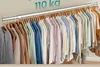 A clothes rack filled with various clothing items hanging on hangers. Náhled obrázku produktu