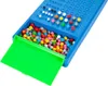 A close-up shot of a blue Mastermind game board with a green tray filled with colorful game pieces. Anteprima dell’immagine prodotto