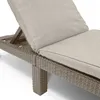 Close-up of a beige cushioned lounge chair with a woven brown frame. Voir les images du produit