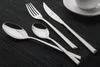 A set of silverware laid out on a black placemat. Produktbild-Vorschau