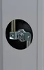 A close-up view of a metal bracket holding two pipes, seen through a circular opening in a gray surface. Produktbild-Vorschau