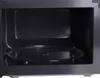 The interior of a black microwave oven with a glass turntable. Voir les images du produit