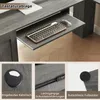 A collage of images showing details of a gray L-shaped computer desk, including a keyboard tray, cable management, drawer slides, and anti-slip feet. Produktbild-Vorschau