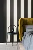 A bedroom scene with a striped wall, a bedside table with a decorative bird, and a bed with a yellow headboard. Produktbild-Vorschau