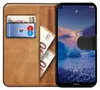 A book-style phone case with a phone inside, showing cards and money in the wallet section. Anteprima dell’immagine prodotto