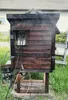 A wooden smoker with electrical components attached, set up outdoors in a grassy area. Náhled obrázku produktu