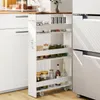 A narrow rolling cart filled with jars and bottles is placed next to a refrigerator and kitchen cabinets. Voir les images du produit