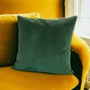 A green corduroy pillow is placed on a yellow sofa. Produktbild-Vorschau