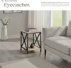 A side table with books and a decorative object is placed next to a sofa in a living room. Náhled obrázku produktu