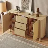 A modern wooden sideboard with open doors and drawers, displaying books, decorative items, and a woven basket. The sideboard is placed on a rug in a room with a floor lamp and artwork on the wall. Voir les images du produit