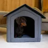 A dachshund dog sits inside a grey fabric dog house. Produktbild-Vorschau