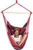 A woman is sitting in a striped hammock chair. Náhled obrázku produktu