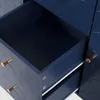 A close-up view of an open navy blue drawer with gold handles on a dresser. Voir les images du produit