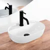 A white oval countertop sink with a black faucet is shown on a wooden countertop, with a reflection in a mirror. Náhled obrázku produktu
