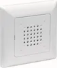 A white wall-mounted electrical component with a perforated grille. Anteprima dell’immagine prodotto