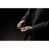 A person in a black jacket is holding a black leather key organizer with keys. Produktbild-Vorschau