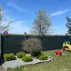A backyard scene with a fence, trees, bushes, and children's toys. Podgląd zdjęcia produktu