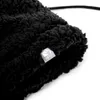 Close-up of a black fuzzy balaclava with a small tag. Produktbild-Vorschau