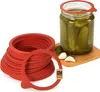 A stack of red rubber jar sealing rings and a jar of pickles with garlic and dill. Anteprima dell’immagine prodotto