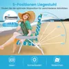 A woman sits on a beach chair on a sandy beach with the ocean in the background. Produktbild-Vorschau