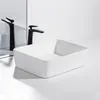 A white ceramic vessel sink with a black faucet is shown on a white countertop with a mirror reflection. Podgląd zdjęcia produktu