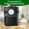 A close-up of a black pasta maker attachment on a wooden surface with a pile of fresh pasta in front. The background shows a blurry kitchen scene and a green banner with German text at the top. Produktbild-Vorschau
